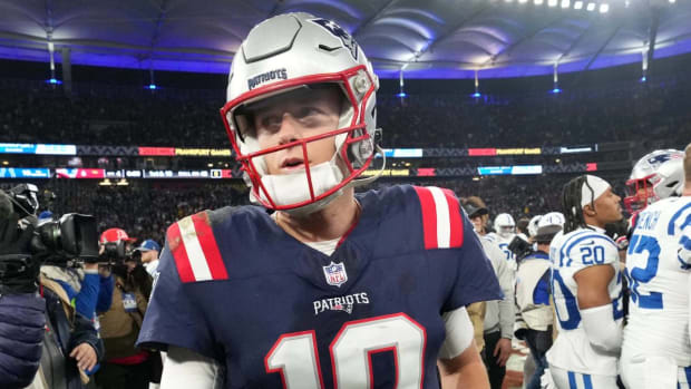 Mac Jones walks off the field after a loss to the Colts.